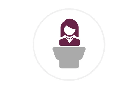Icon: stilisierte weibliche Person in dunklem Rot vor einem grauen Rednerpult, Symbol für Staatsministerin