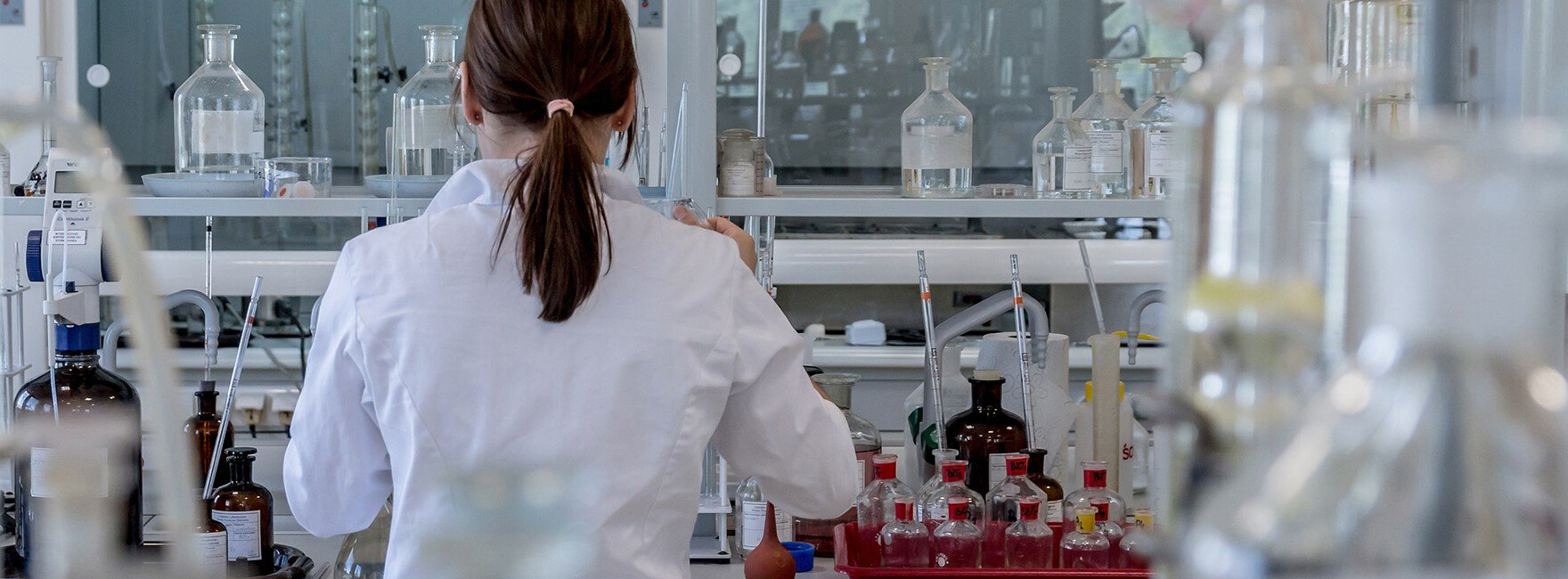 Looking into a medical laboratory, a laboratory worker works at her workplace